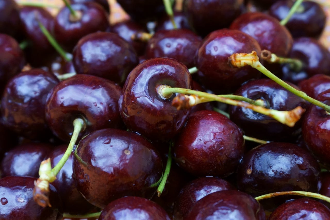 A vibrant close-up of fresh, juicy red cherries with stems, showcasing their glossy texture.